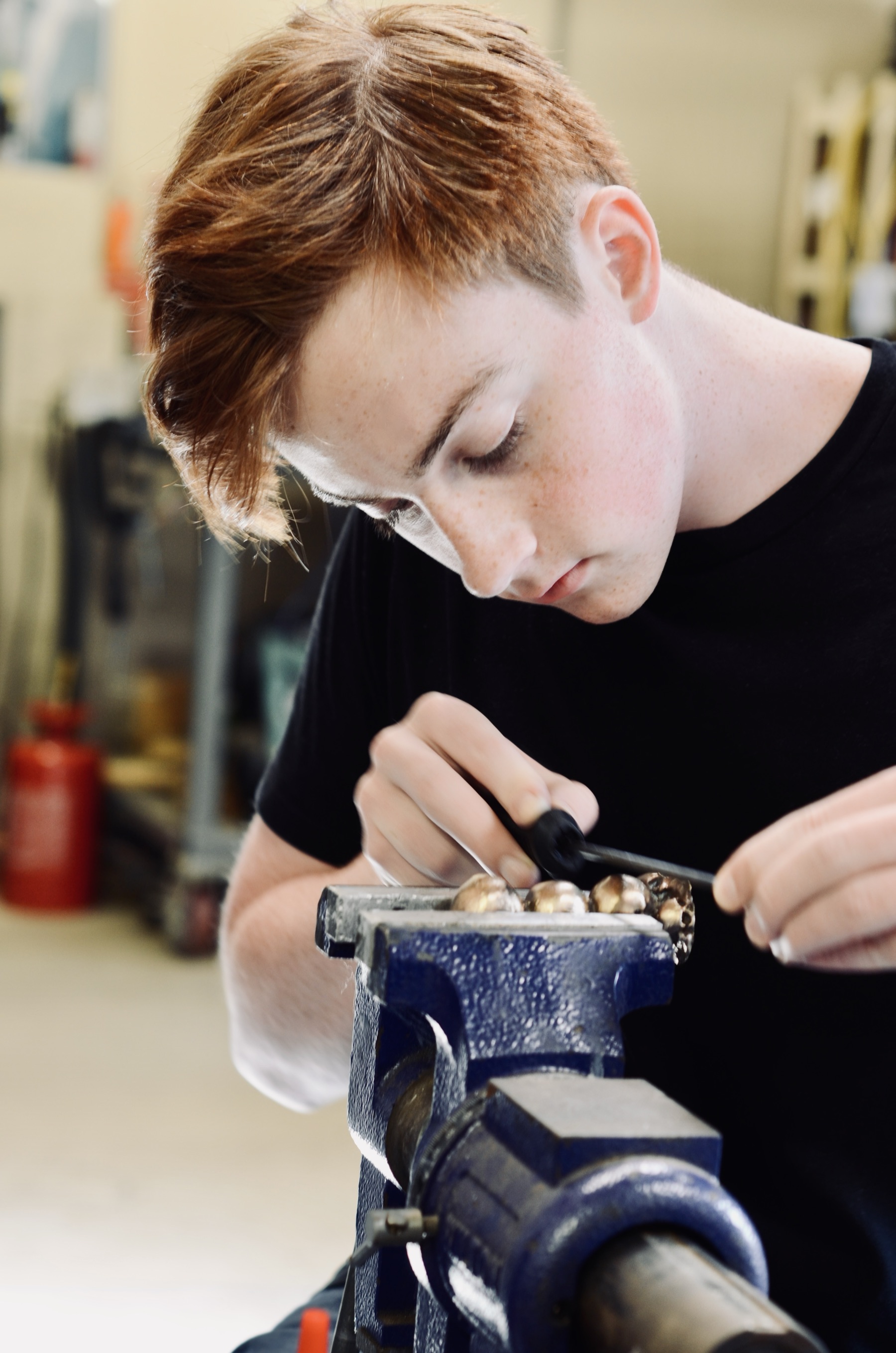 Grayson Richmond filing a workpiece in the shop